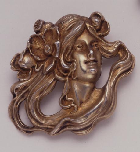 Brooch in the form of a woman's head with swirling hair