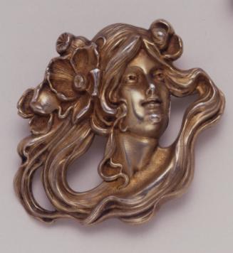 Brooch in the form of a woman's head with swirling hair