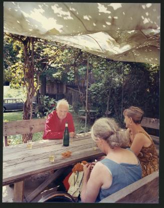 Alexander Calder sitting at a picnic table